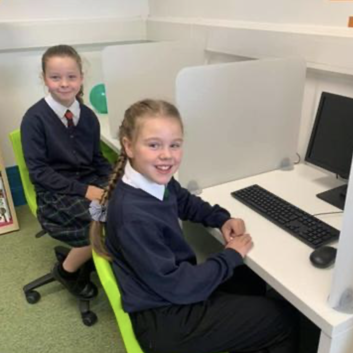 Two girls are sat at desks for a computing lesson in school